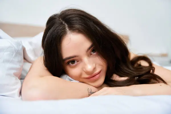 A beautiful young woman relaxes gracefully on her side, exuding calmness in a cozy room ambiance. — Stock Photo