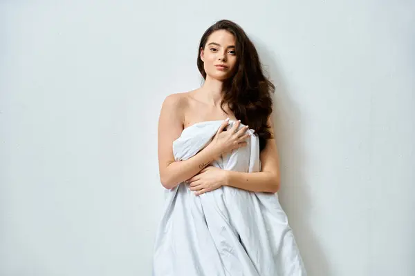 A graceful young woman holds a white cloth, radiating confidence and allure. — Stock Photo