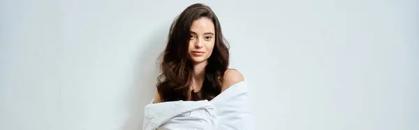 A young woman with long hair relaxes while wrapped in soft fabric, exuding an aura of tranquility. — Stock Photo