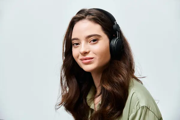 A beautiful young woman listens to music, absorbed in her own world, wearing sleek black headphones. — Stock Photo