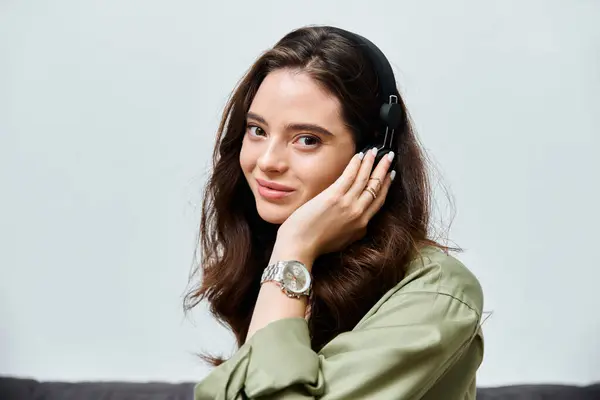 Beautiful young woman listens to music with headphones, smiling and exuding a relaxed vibe indoors. — Stock Photo