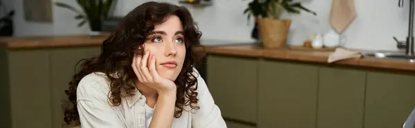 Une charmante jeune femme repose son menton sur sa main tout perdu dans la pensée à la maison dans une cuisine élégante. — Stock Photo