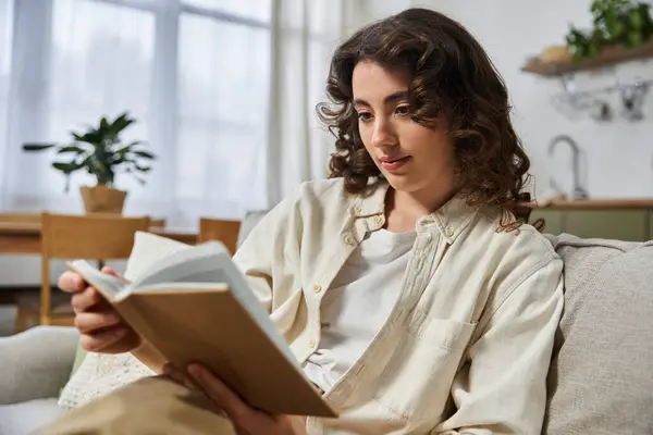 Молодая женщина наслаждается увлекательной книгой дома в мирный день. — стоковое фото