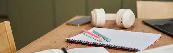Colourful stationery and headphones on table in well lit room. — Stock Photo
