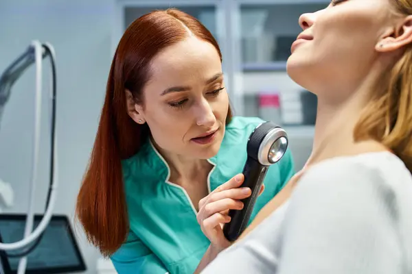 Professionnel qualifié en dermatologie examine soigneusement la peau d'un beau jeune patient en clinique. — Photo de stock