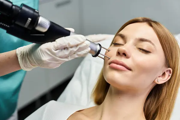 Un praticien traite une femme détendue pour le rajeunissement de la peau en dermatologie. — Photo de stock