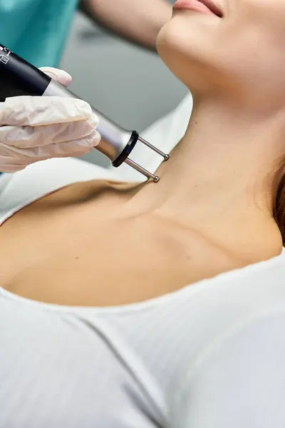 Una mujer joven y hermosa recibe un tratamiento dermatológico enfocado en mejorar la salud de su piel. - foto de stock
