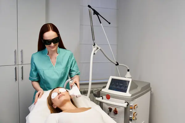 A professional performs a dermatological procedure on a young woman in protective eyewear. — Stock Photo