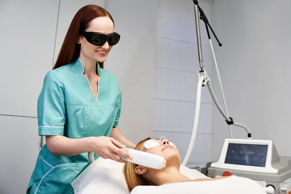 Un praticien qualifié applique un traitement dermatologique à un jeune client, assurant confort et soins. — Photo de stock