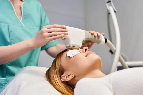 Un praticien qualifié effectue un traitement de la peau sur une jeune femme axée sur l'amélioration de sa beauté. — Photo de stock
