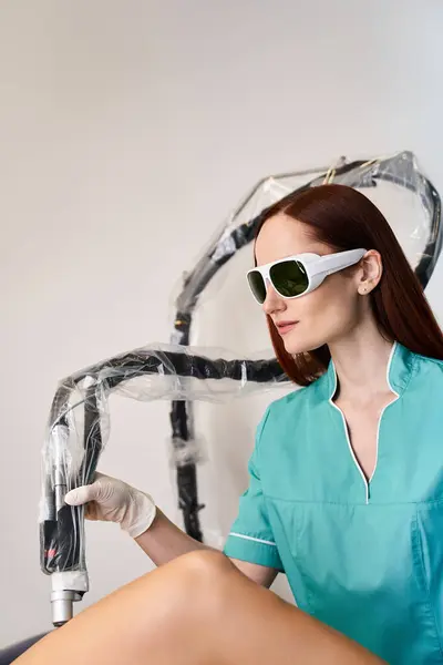 A young, beautiful woman wearing protective glasses relaxes before undergoing laser hair removal. — Stockfoto