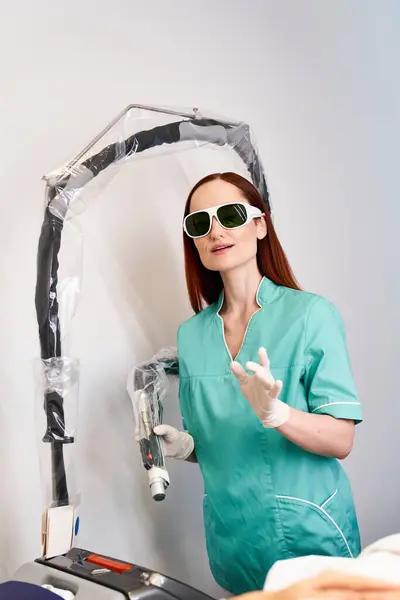 Un giovane professionista spiega la procedura di depilazione laser in una clinica invitante. — Foto stock