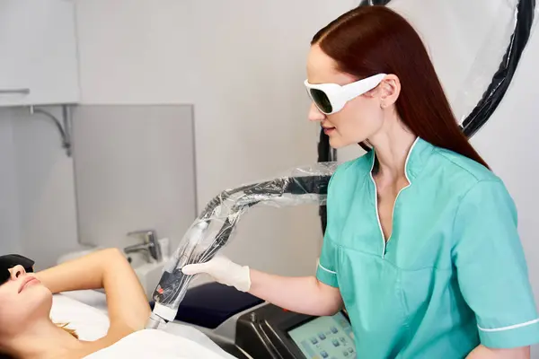 Technicien démontre l'épilation au laser, mettant en évidence les méthodes modernes de traitement de beauté. — Photo de stock