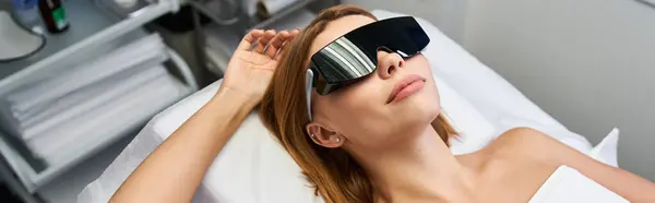 Uma jovem mulher desfruta de um procedimento de depilação a laser em um ambiente clínico contemporâneo. — Fotografia de Stock