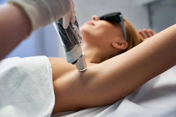 Un giovane, bellissimo individuo subisce un trattamento di depilazione laser in un ambiente sereno — Foto stock