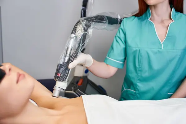 Une jeune femme se fait épiler au laser dans une clinique moderne. — Photo de stock