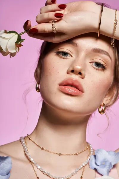 A stylish young woman poses, showcasing her chic accessories and bright flower. — Stock Photo
