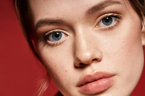 A young woman with flawless skin and captivating blue eyes highlights her chic style and confidence. — Stock Photo
