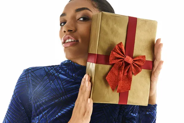 Elegant young woman presents a beautifully wrapped gift with style and charm. — Stock Photo