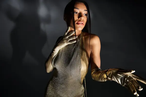 Young woman in chic golden attire showcasing elegance and style during a nighttime fashion shoot. — Stock Photo