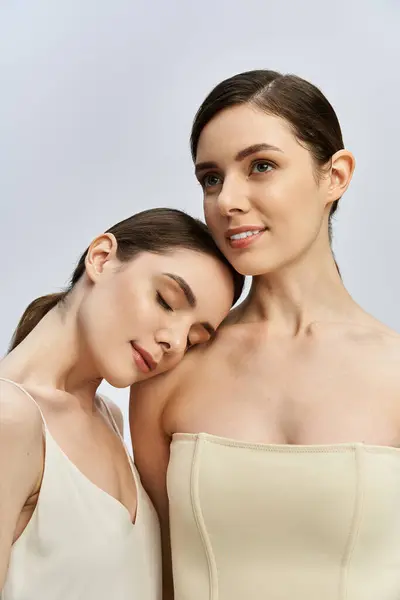 Two pretty twin sisters share a tender moment, displaying their close bond and natural beauty. — Stock Photo