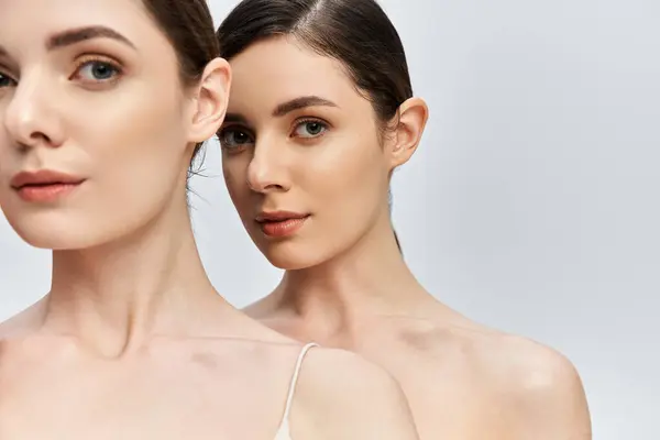 Dos hermosas hermanas están juntas, sus rasgos radiantes iluminados por la luz suave. — Stock Photo