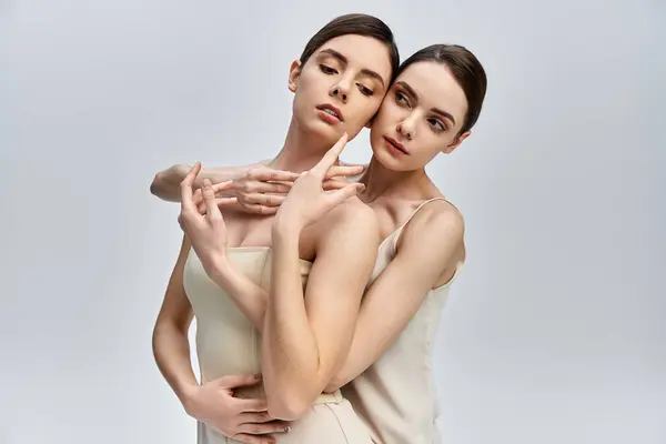 Two pretty sisters convey deep connection and elegance with their graceful poses and expressions. — Stock Photo