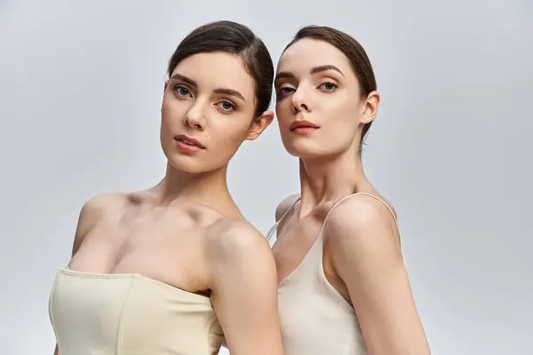 Two lovely twin sisters pose beautifully together, highlighting their bond and features. — Stock Photo