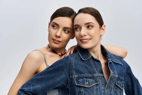 Two pretty sisters embrace each other, smiling and enjoying their time while dressed up. — Stock Photo