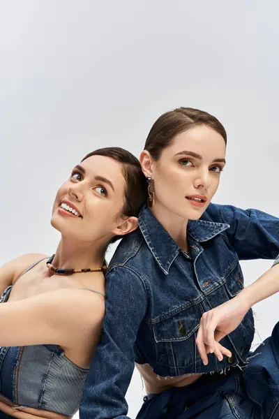Twins express their individuality through trendy outfits and bright smiles in a stylish setting. — Stock Photo