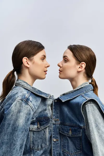 Two beautiful sisters stand side by side, showcasing their unique bond and fashion sense outdoors. — Stock Photo