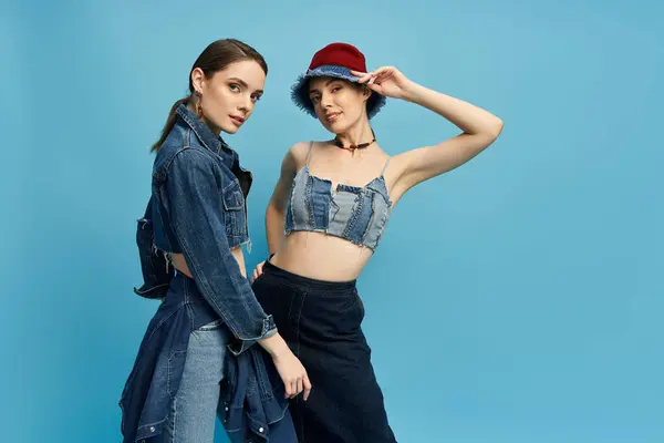 Deux sœurs jumelles élégantes mettent en valeur avec confiance leurs personnalités vibrantes en denim tendance. — Photo de stock
