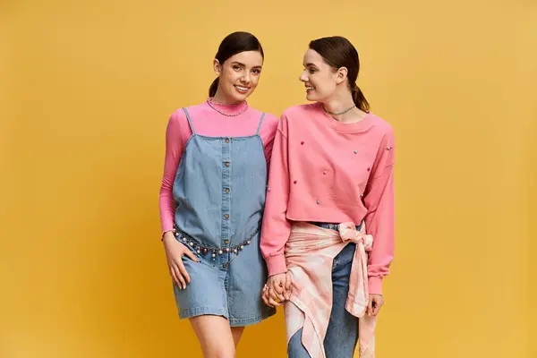 Deux belles femmes partagent un moment joyeux alors qu'elles sont vêtues de tenues à la mode, soulignant leur lien. — Photo de stock