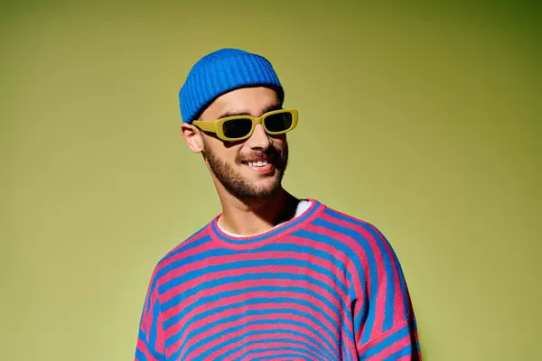 A smiling young man confidently displays his trendy fashion sense in a bright studio. — Stock Photo
