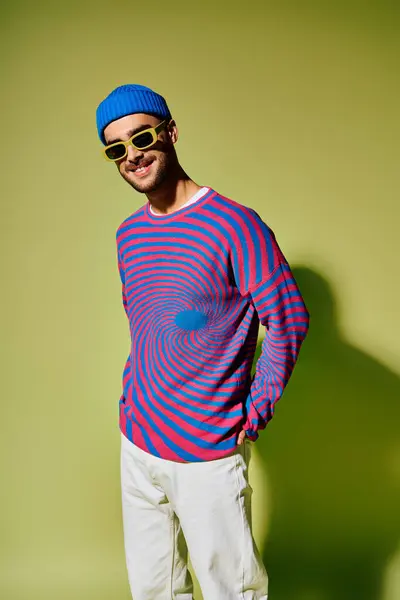 A fashionable young man shows off his style in a vibrant outfit and trendy sunglasses. — Stock Photo