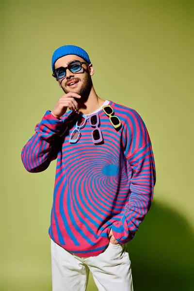 A stylish young man showcases bold colors and trendy sunglasses in a studio. — Stock Photo