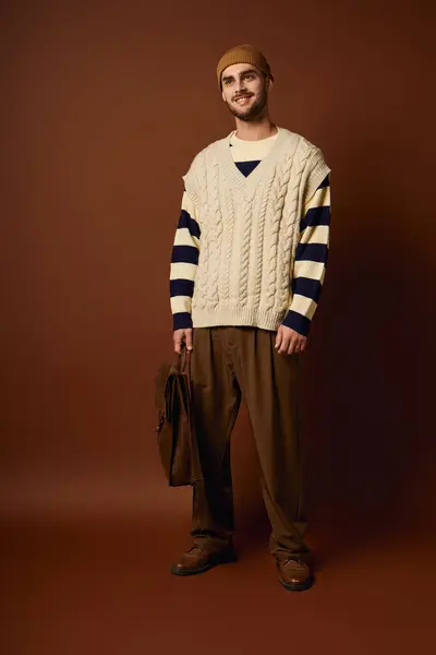 A stylish young man stands confidently in a studio with a vibrant backdrop. — Stock Photo