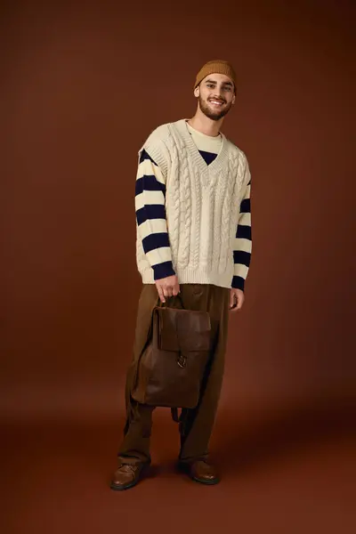 Handsome young man showcases his winter fashion style with a trendy beanie and stylish outfit. — Stock Photo