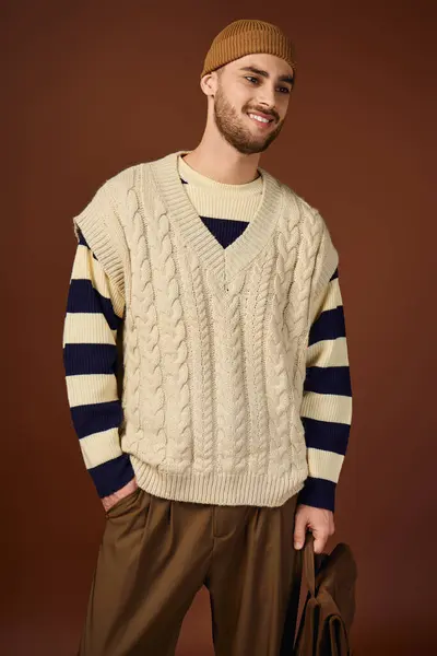 Handsome young man displays his unique fashion sense with a beanie and stylish outfit in a studio. — Stock Photo