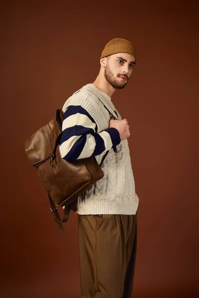 Young man demonstrates his unique fashion sense, wearing a knitted beanie and stylish outfit. — Stock Photo