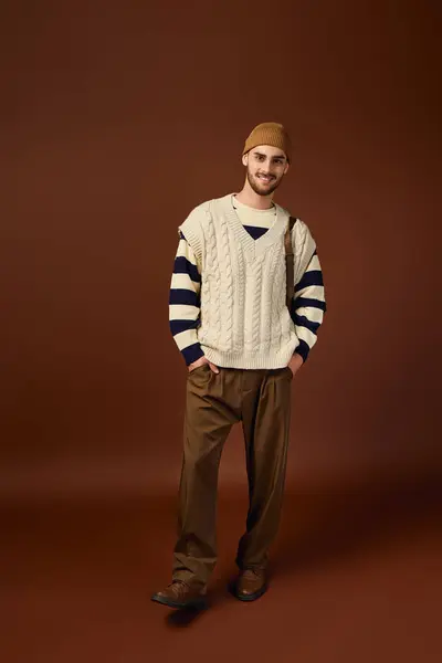A young man expresses his unique fashion sense in a trendy outfit with a beanie hat. — Stock Photo