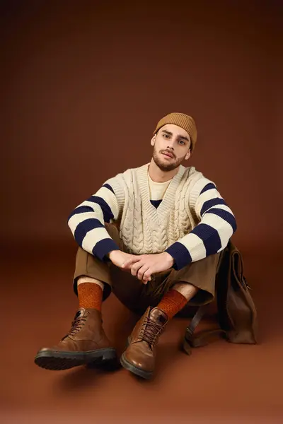 Joven guapo muestra su sentido único de la moda en un ambiente de estudio moderno. - foto de stock