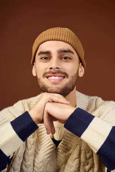 A young man showcases his unique style in a cozy knitted sweater and beanie. — Stock Photo