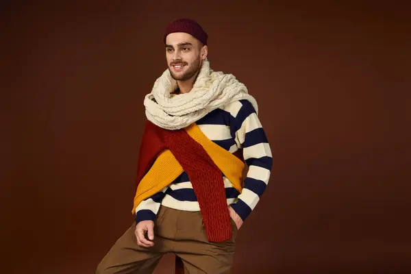 Handsome young man displays his fashionable winter outfit while posing in a studio setting. — Stock Photo