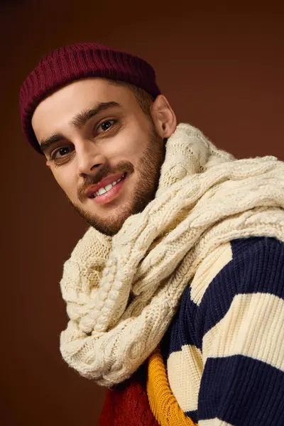 Handsome young man displays his unique fashion style in a studio with a brown background. — Stock Photo