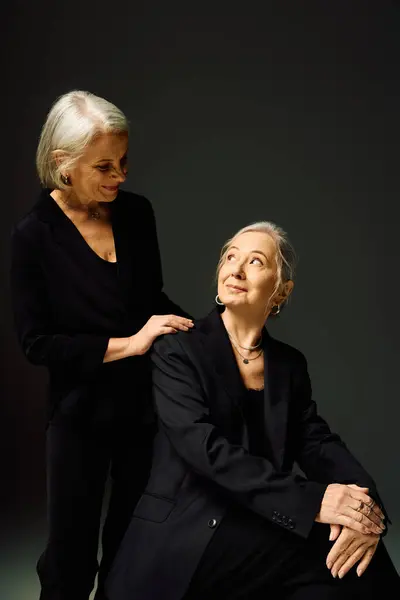 Two stylish women share an intimate moment filled with affection and confidence in a sleek setting. — Stock Photo
