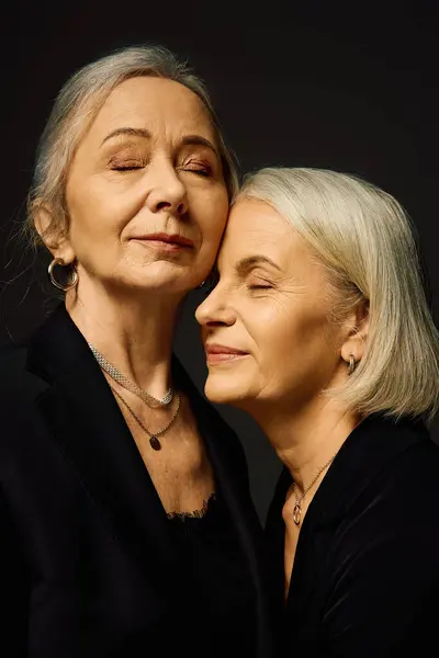 Two mature women share a tender moment, eyes closed, embodying romance and stylish sophistication. — Stock Photo