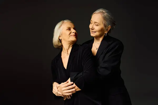 Two joyful women embrace, highlighting their unique fashion and deep bond in a stylish scene. — Stock Photo