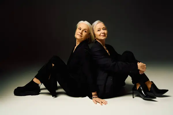 Two stylish women share a tender moment, highlighting their bond in an elegant setting. — Stock Photo