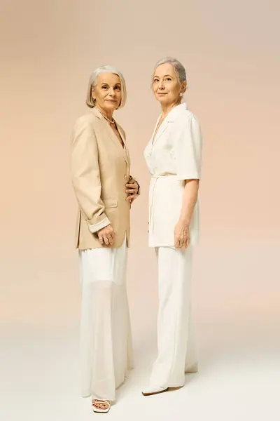 Two stylish mature women display their romance and bond through chic outfits and confident poses. — Stock Photo